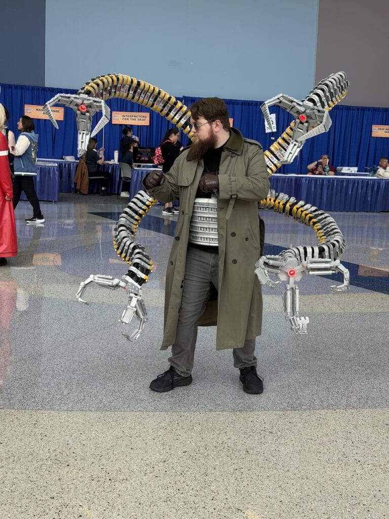 John Brandes in a Doctor Octopus cosplay with mechanical tentacle arms at a convention floor in Anaheim